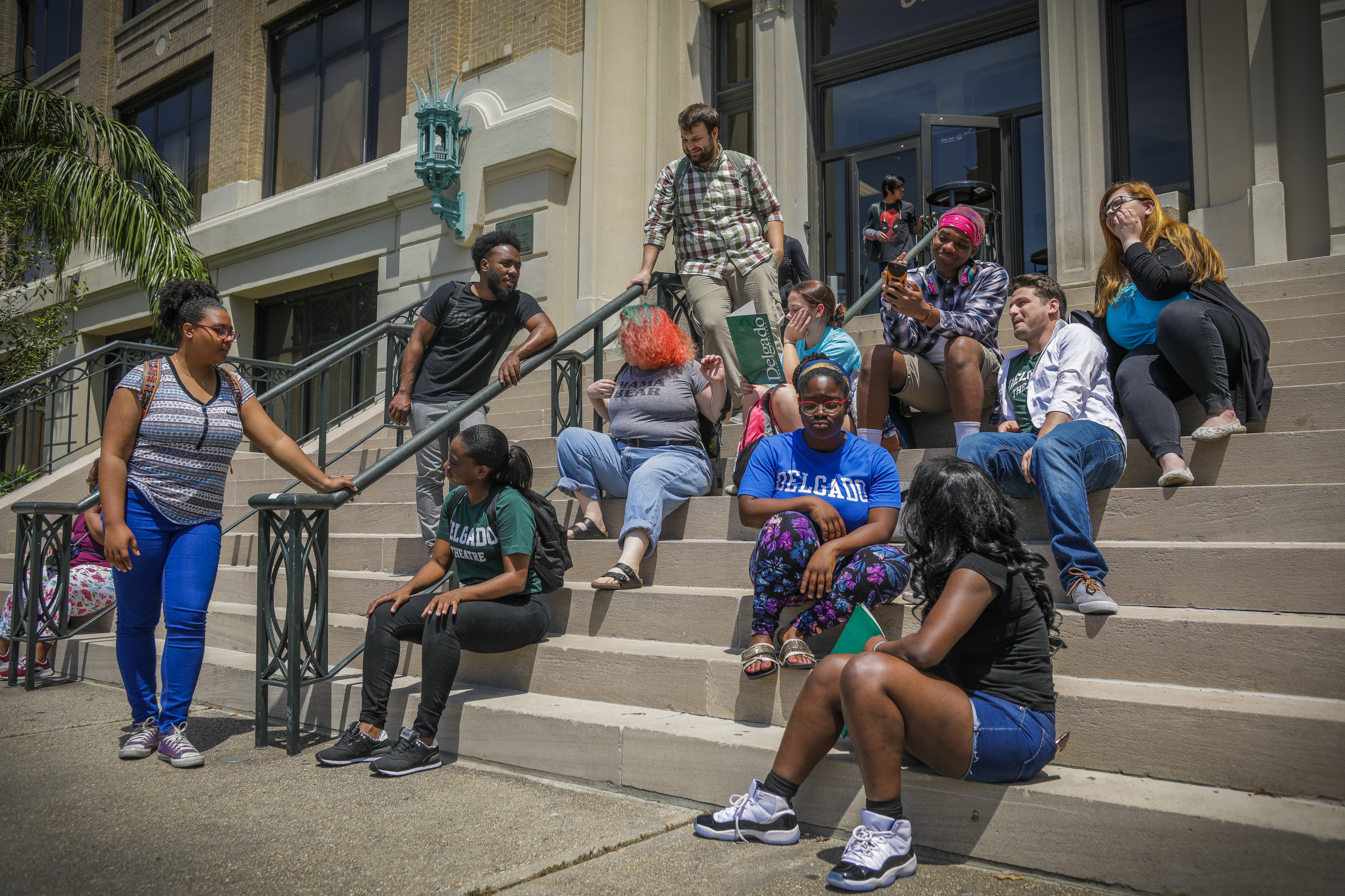 Diverse group of students socializing and studying on the steps of Isaac Delgado Hall (Building 1) at the City Park Campus